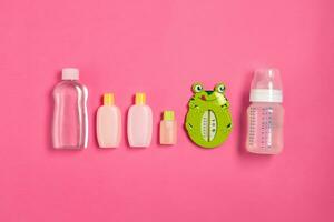 Baby accessories for bath with frog on pink background. Top view photo