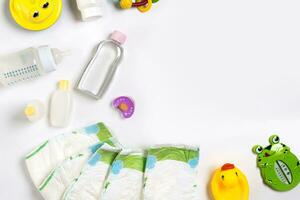 Babies goods diaper, baby powder, cream, shampoo, oil on white background with copy space. Top view or flat lay. photo