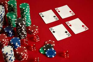 Casino gambling poker equipment and entertainment concept - close up of playing cards and chips at red background. Four of a Kind photo