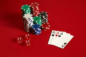Casino gambling poker equipment and entertainment concept - close up of playing cards and chips at red background. Three of a Kind photo