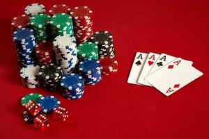 Casino gambling poker equipment and entertainment concept - close up of playing cards and chips at red background. Four of a Kind photo