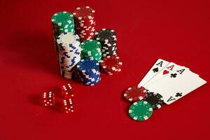 Casino gambling poker equipment and entertainment concept - close up of playing cards and chips at red background. Three of a Kind photo