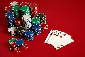 Casino gambling poker equipment and entertainment concept - close up of playing cards and chips at red background. Four of a Kind photo