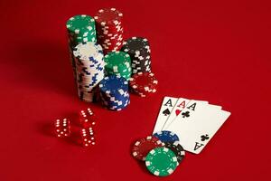 Casino gambling poker equipment and entertainment concept - close up of playing cards and chips at red background. Three of a Kind photo