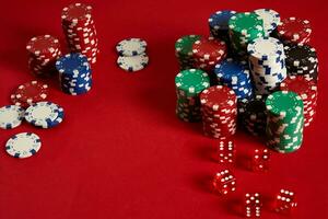 Poker chips on red background. Group of different poker chips. Casino background. photo