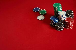 Poker chips on red background. Group of different poker chips. Casino background. photo