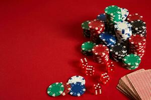 Poker chips and Card deck on red background. Group of different poker chips. Casino background. photo