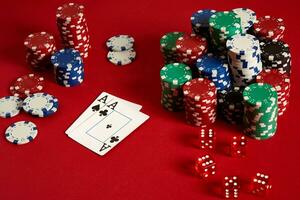 Poker chips and aces on red background. Group of different poker chips. Casino background. photo