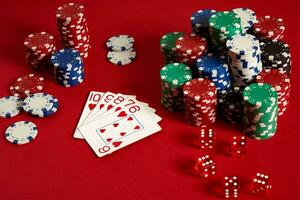 Casino gambling poker equipment and entertainment concept - close up of playing cards and chips at red background. Straight Flush photo