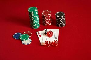Poker chips and aces on red background. Group of different poker chips. Casino background. photo
