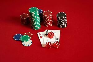 Poker chips and aces on red background. Group of different poker chips. Casino background. photo