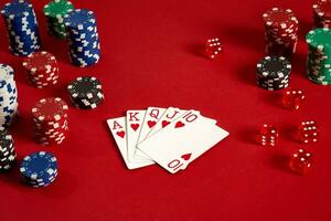 Poker cards and gambling chips on red background photo