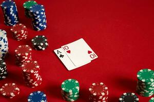 Poker cards and gambling chips on red background photo