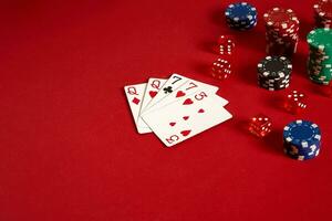 Poker cards and gambling chips on red background photo