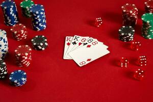 Poker cards and gambling chips on red background photo