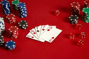 Poker cards and gambling chips on red background photo