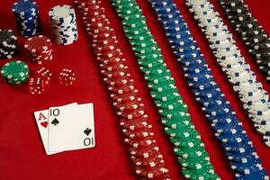 Poker cards and gambling chips on red background photo