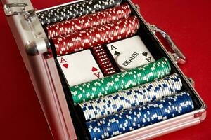 Poker set in metal suitcase. Risky entertainment of gambling. Top view on red background photo