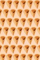 Sugar waffle cone for ice cream arranged in pattern on pink background. The image with copy space can be used as a background for the design of the confectionery menu photo