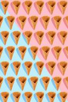 Sugar waffle cone for ice cream arranged in pattern on pink and mint background. The image with copy space can be used as a background for the design of the confectionery menu photo