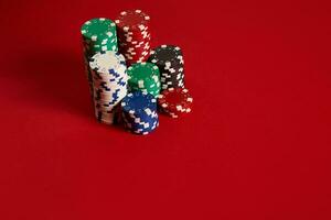 Poker chips on red background. Group of different poker chips. Casino background. photo