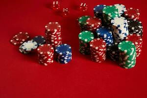 Poker chips on red background. Group of different poker chips. Casino background. photo