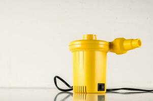 a yellow water pump sitting on top of a table photo