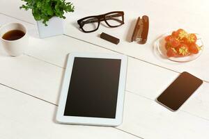 Flower pot, glasses, tablet, smart on white desktop photo