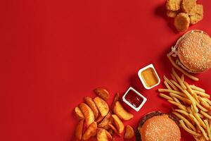 Burger and Chips. Hamburger and french fries in red paper box. Fast food on red background. photo