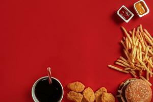 Burger and Chips. Hamburger and french fries in red paper box. Fast food on red background. photo