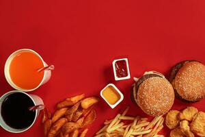 Burger and Chips. Hamburger and french fries in red paper box. Fast food on red background. photo