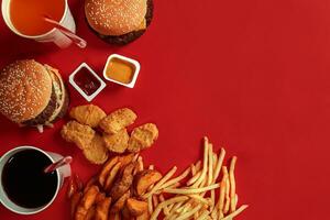 Burger and Chips. Hamburger and french fries in red paper box. Fast food on red background. photo