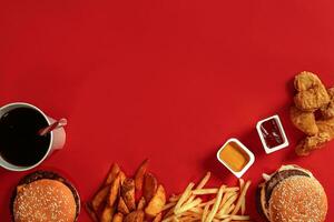 Burger and Chips. Hamburger and french fries in red paper box. Fast food on red background. photo