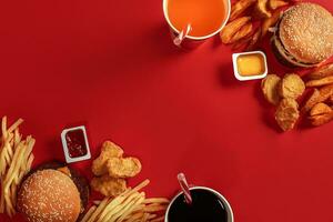 Burger and Chips. Hamburger and french fries in red paper box. Fast food on red background. photo