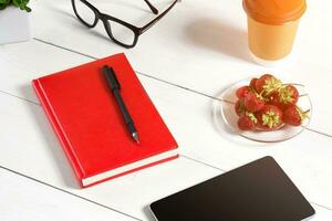 Stylish minimalistic workplace with tablet and notebook and glasses in flat lay style. White background. photo