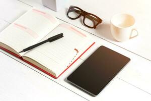 Stylish minimalistic workplace with tablet and notebook and glasses in flat lay style. White background. photo