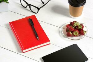 Stylish minimalistic workplace with tablet and notebook and glasses in flat lay style. White background. photo