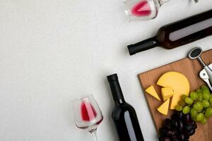 Two glasses of red wine, cheese and grapes. Top view photo