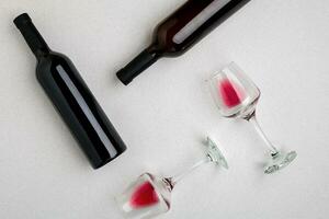 Glasses and bottles of red and white wine on white background from top view photo