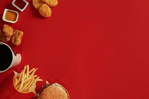 Burger and Chips. Hamburger and french fries in red paper box. Fast food on red background. photo