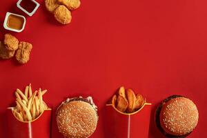 Burger and Chips. Hamburger and french fries in red paper box. Fast food on red background. photo