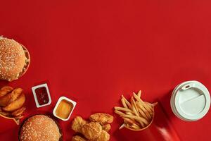 Burger and Chips. Hamburger and french fries in red paper box. Fast food on red background. photo