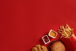 Concept of mock up burger, potatoes, sauce on red background. Copy space for text and logo. photo