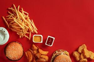 Burger and Chips. Hamburger and french fries in red paper box. Fast food on red background. photo