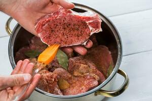 Close up of chefs hands spicing the meat photo