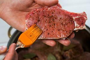 cerca arriba de cocineros manos condimentando el carne foto