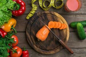 Glass of tomato juice with vegetables and measuring tape on table close-up photo