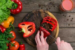 Female hands cutting pepper at table, top view photo