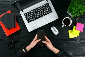 Mix of office supplies and gadgets on a wooden desk background. View from above. photo