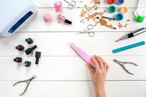 Manicure set and nail polish on wooden background photo